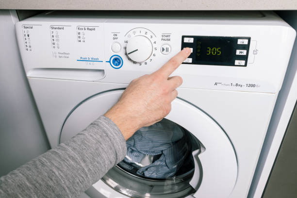 istock PRESSING A BUTTON ON THE WASHER TO SELECT A WASH FEATURE 1459389680