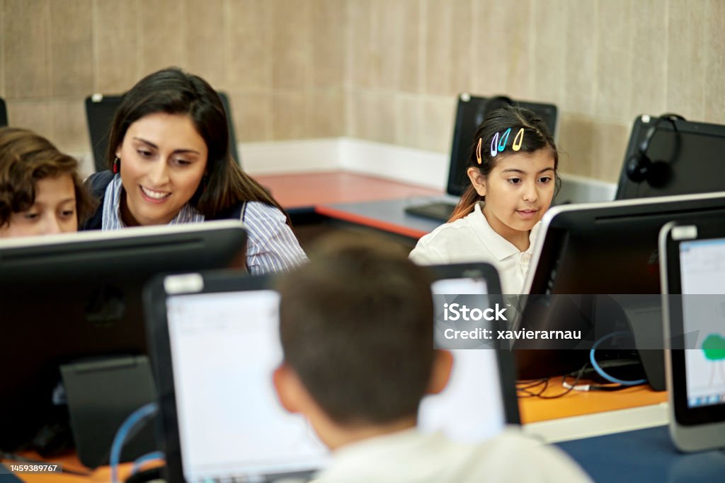 Computer Lesson Instructor Instructor Helping Elementary Students In Computer Lab Stock Photo ...