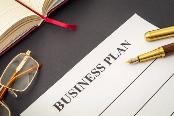 istock Blank form and pen, glasses, notepad for drawing up business plan on black table 1459390043