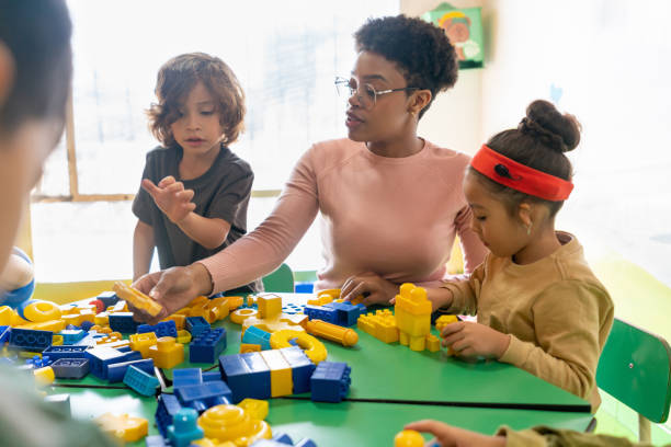 Teacher playing with toy blocks in class at the school African American teacher playing with toy blocks in class at the school - education concepts special education stock pictures, royalty-free photos & images
