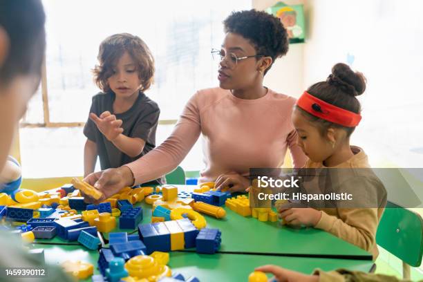 Teacher Playing With Toy Blocks In Class At The School Stock Photo - Download Image Now