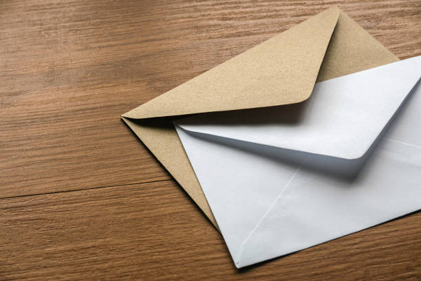 istock Brown and white envelope on a wooden background. 1459390615