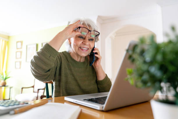 istock Senior woman at home working on her laptop and using reading glasses 1459391168