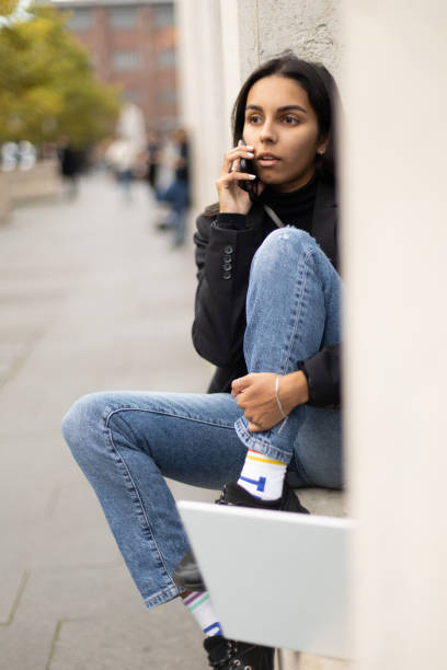 istock Young student woman sitting outside with laptop 1459392251