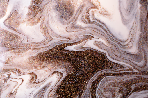 Shimmer liquid stripy background from liquid nail polishes,brown and milky colors.