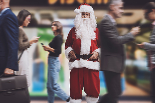 Santa Claus standing in a crowded city street and staring at camera, contemporary Christmas concept