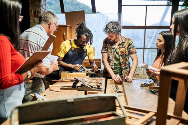 istock Group of multiracial people learning carpentry at woodworking class 1459392559