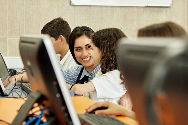 istock Teacher and school children in computer lab 1459393356