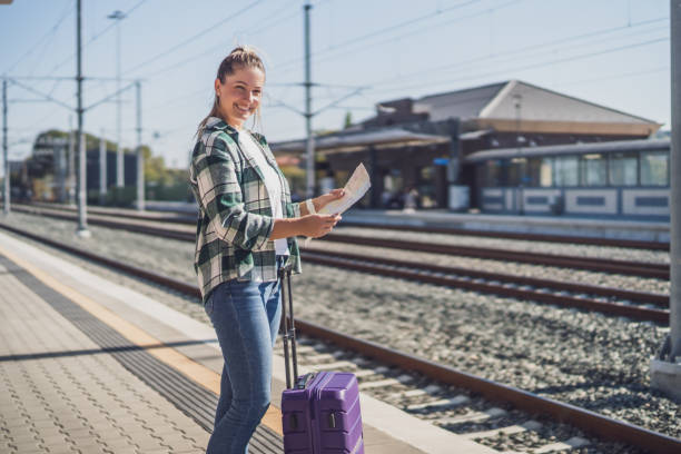istock Woman looking at map while standing on a train station 1459394724