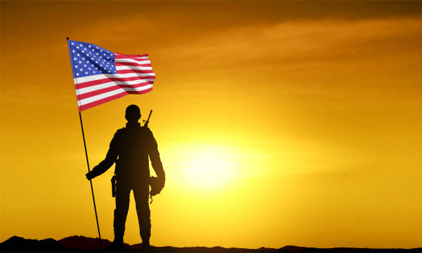 istock Silhouette of a soldier with an American flag in his hands 1459396918