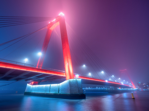 Willemsbrug, Rotterdam, Netherlands. View of the Willems bridge and the city center. Foggy weather. Panoramic view. Cityscape in the evening. Night landscape.