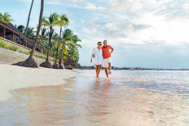 istock Couple in love hugging while walking on a sandy exotic beach. They have an evening walk by Trou-aux-Biches seashore on Mauritius island. People relationship and tropic honeymoon vacations concept 1459398584