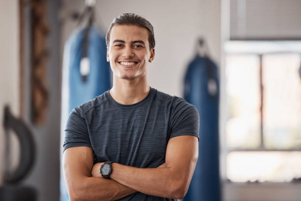 gimnasio, fitness y retrato de hombre orgulloso de pie con sonrisa, motivación, salud y energía para entrenar. entrenador, entrenador personal o propietario de un club de boxeo feliz en el estudio para entrenamiento, entrenamiento y bienestar - gym machine smiling coach fotografías e imágenes de stock