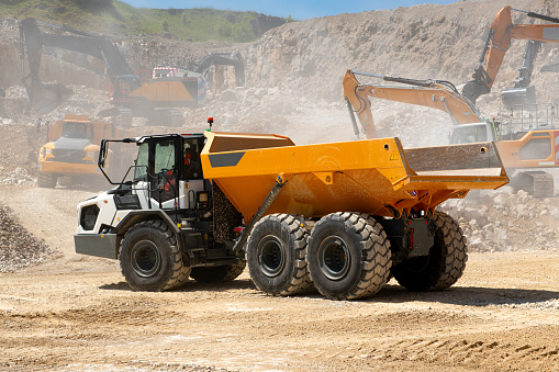 A dumper truck in a dusty quarry in summertime