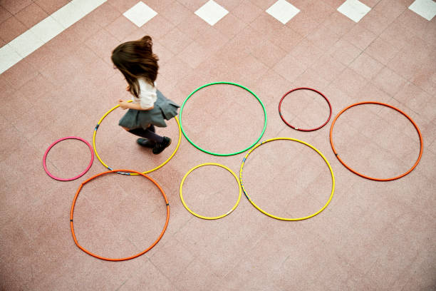 istock Young girl playing hopscotch with plastic hoops 1459399607