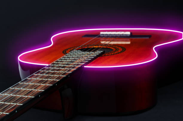 istock Acoustic  guitar with glowing neon border  on a black background 1459401402