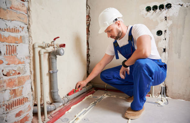 Man checking plumbing pipe with spirit level tool in apartment.