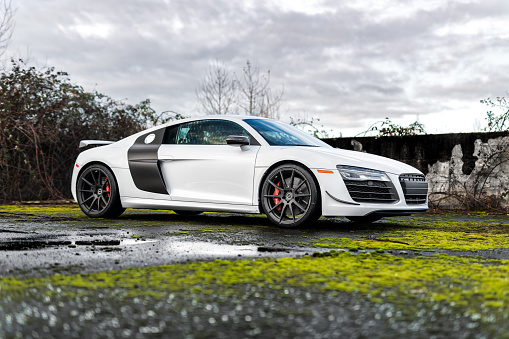 Seattle, WA, USA\nJanuary 24, 2023\nWhite Audi R8 parked showing the passenger side of the car and green moss