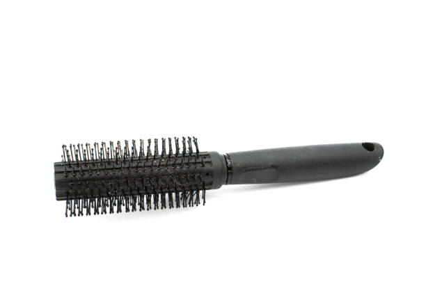 Dirty round hair brush, isolated on white.