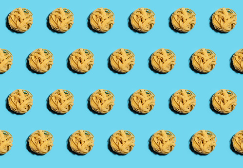 Tagliatelle uncooked pasta pattern on blue background