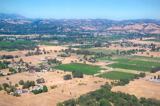 view from above of farmland in summer with mountains in backgrounds
