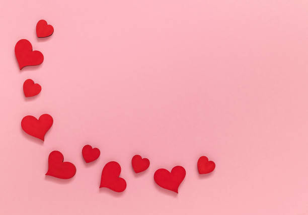 istock Festive frame with red wooden hearts on a pink background. 1459412520