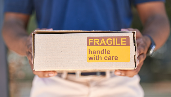 Hands, logistics and box for special delivery, cargo or handle with care in transport or shipping. Hand in stock deliver holding fragile cardboard box for online purchase, export or courier service