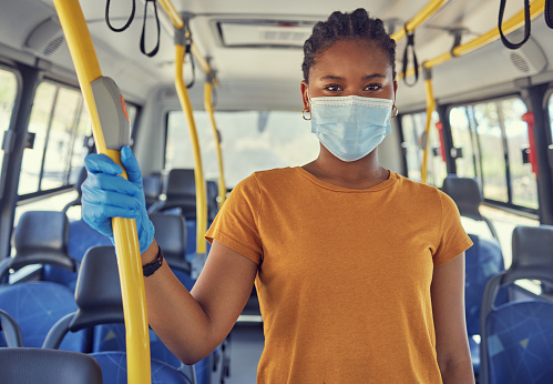 Transport, covid and portrait of black woman on bus travelling on public transport in city. Travel, commute and girl with medical gloves and face mask for health, safety and protection in pandemic