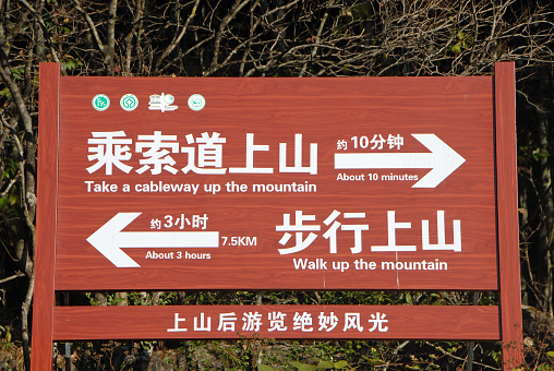 Huangshan Mountain in Anhui Province, China. Sign near Yungu cable car station at the base of Huangshan giving directions for walking or the cableway.