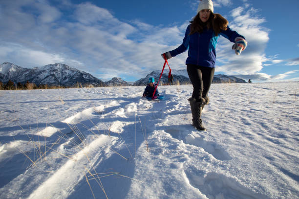 istock Mother pushes young daughter down sledding hill 1459420667