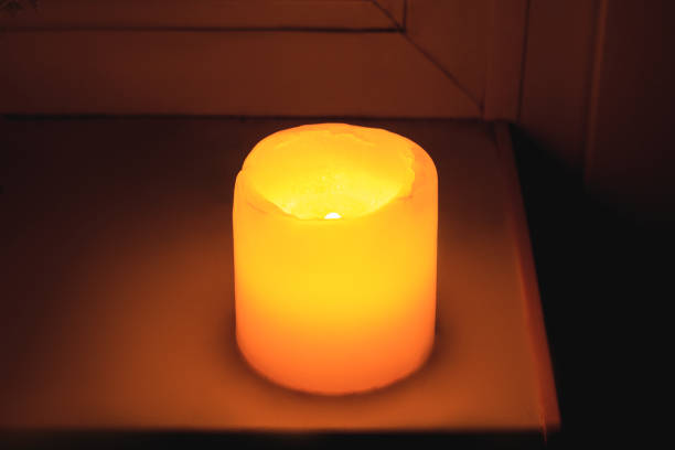 istock The yellow candle shines a warm light on the windowsill. 1459422599