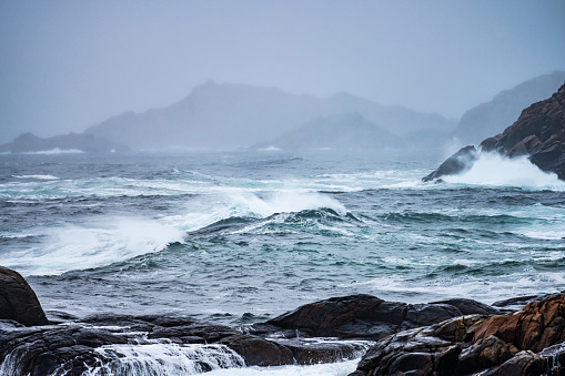 Waves crashing against cliffs during a winter storm.