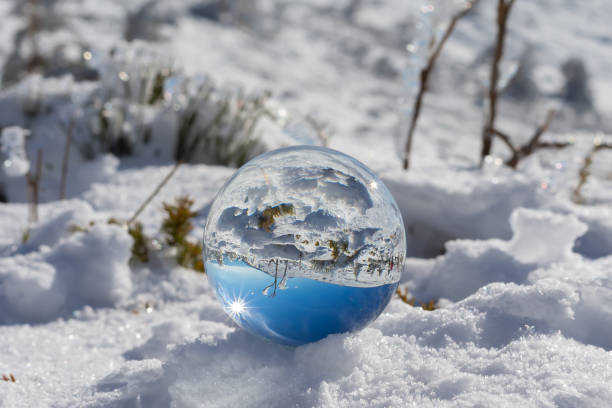 晴れた日に雪と青い空を持つ山の風景の水晶玉に映る。 冬の写真。 山の吹雪。 - spirituality growth hope crystal ball ストックフォトと画像