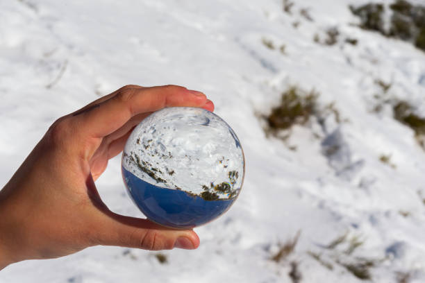 晴れた日に雪と青い空を持つ山の風景の水晶玉に映る。 冬の写真。 山の吹雪。 - spirituality growth hope crystal ball ストックフォトと画像