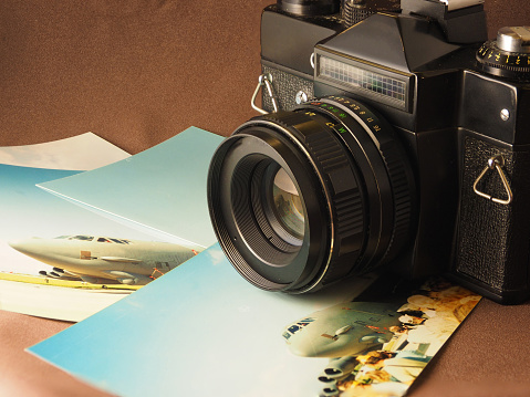 Still life with an old film, SLR camera and printed photos, close-up.