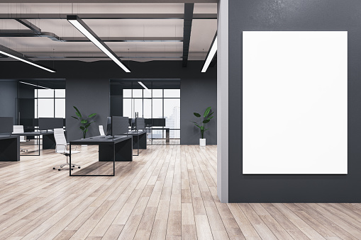 Modern coworking office interior with blank mock up banner on wall, wooden flooring, windows, equipment, furniture and other items. 3D Rendering