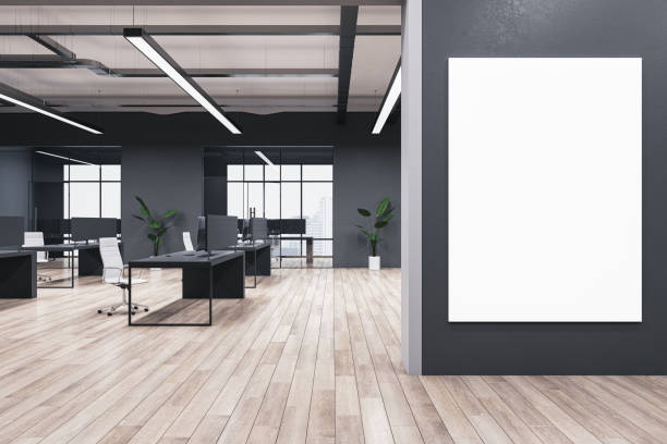 Modern coworking office interior with blank mock up banner on wall, wooden flooring, windows, equipment, furniture and other items. 3D Rendering. stock photo