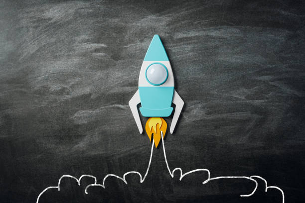 istock Startup and business concept with taking off bright graphic rocket on dark chalkboard background. 3D rendering 1459431345