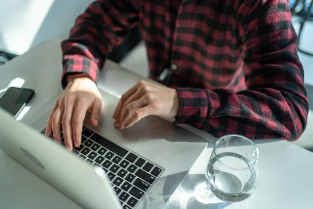 istock Freelancer working on laptop in cafe, close-up on hands and laptop keyboard, top view 1459436601