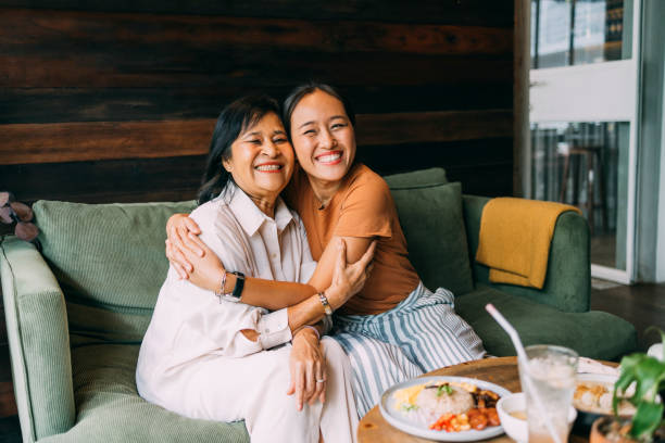 어머니의 날에 카페에 앉아 있는 동안 어머니를 껴안고 있는 행복한 아름다운 여성의 초상화 - family multi ethnic group asian ethnicity cheerful 뉴스 사진 이미지