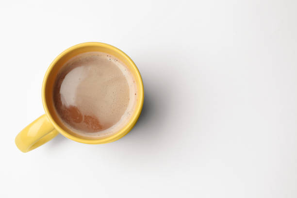 istock Yellow mug of freshly brewed hot coffee on white background, top view. Space for text 1459446280
