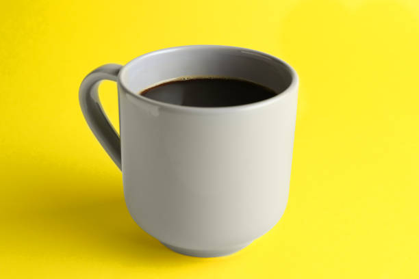istock Grey mug of freshly brewed hot coffee on yellow background 1459446455