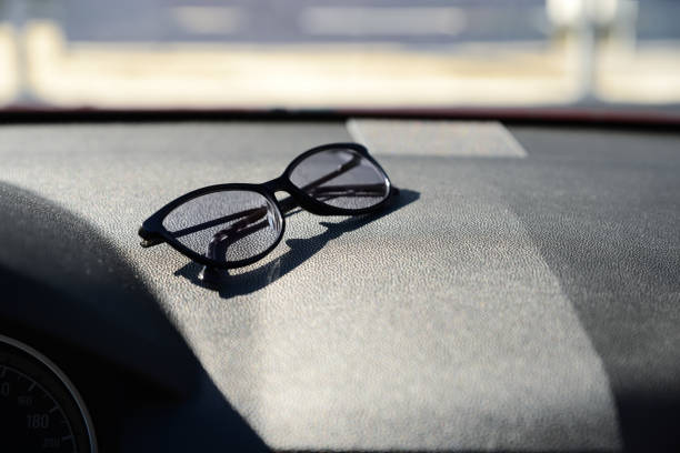 istock Stylish glasses on dashboard in car, space for text 1459446470