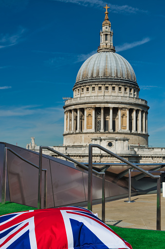 The Dome of St Paul Cathedral in London, English flag in foreground.