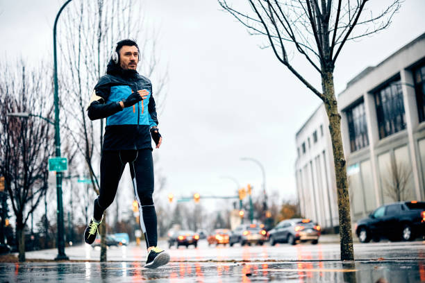 istock Determined sportsman jogging outdoors on rainy day. 1459453196