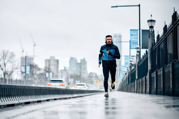 istock Full length of athletic man jogging while exercising in the rain. 1459453319