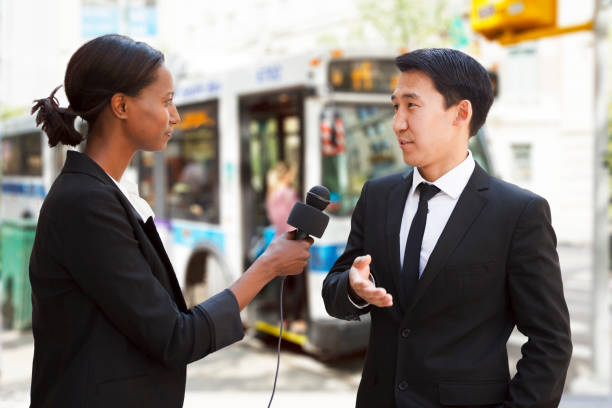 istock Woman Interviews Man at Bus Stop 1459455282