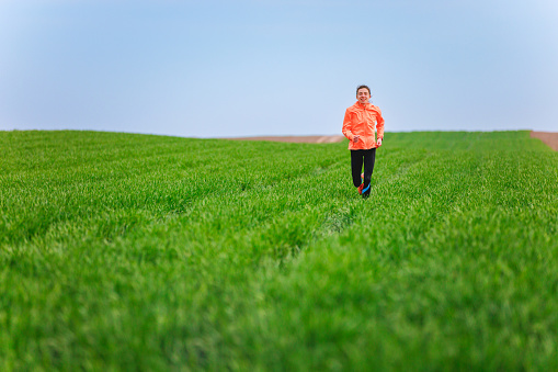 Running on green grass in spring, fit and healthy people