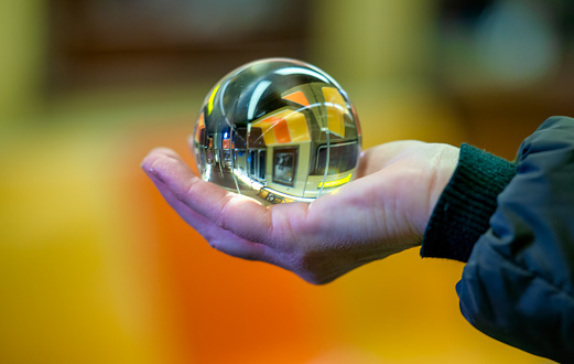 Woman hold a Crystal Ball with subway train reflection.