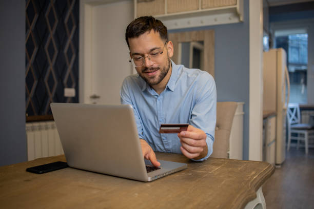 istock Man using his credit card to shop online 1459457142